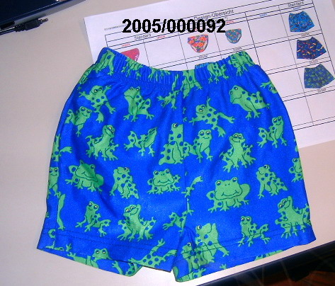 Schwimmwindelhose für Knaben, bestehend aus
- einer gewirkten, bunt bedruckten Aussenhose in Form einer Short aus texturierten, synthetischen Filamentgarnen auf Polyamidbasis mit eingearbeiteten Elastomerfäden aus Polyurethan (nicht Kautschuk),
- einer eingearbeiteten, gewirkten Innenhose auf Polyesterbasis, welche einseitig mit einer dünnen, elastischen Folie auf Polyurethanbasis beschichtet ist.
Hosenbund und Beinöffnungen der Innenhose weisen elastische Abschlüsse auf.
Kein Kleidungsstück für Kleinkinder.