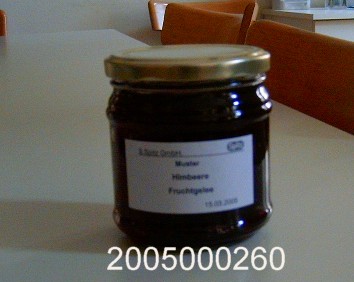 Dunkelrote, klare, gelartige, fruchtig nach Himbeeren riechende und ebenso sowie süß schmeckende, nicht alkoholhaltige, durch Kochen hergestellte Fruchtzubereitung (Fruchtgelee), im Wesentlichen bestehend aus Glucose/Fructosesirup, Himbeersaft, Saccharose sowie Gelier- und Säuerungsmittel mit einem Zuckergehalt von mehr als 30 GHT; aufgemacht in einem etikettierten Glas mit Schraubdeckel zu 450 g.
