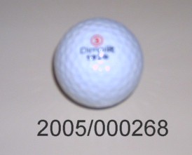 Golfball mit einem Durchmesser von ca. 4 cm; mit 1070 Dimples; mit Firmen- und Produktbezeichnungen bedruckt.
