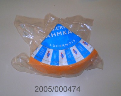 Runder, halbharter, weichschnittiger, vereinzelt kleine Löcher aufweisender Käselaib mit Rinde/Schmiere, Käse aus Kuhmilch mit mildem, tilsiterähnlichem Geschmack und einem Gewicht von ca. 4 – 4,5 kg.