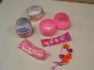 Eine Zusammenstellung von Waren in einer gemeinsamen Umschließung, aus folgenden Produkten bestehend:
-	zwei, jeweils in Wickelpapier verpackte, Ketten in Form von auf einer weißen, elastischen, verknoteten Schnur aufgefädelten, verschiedengefärbten und verschieden großen, teilweise mit Prägung versehenen, teils beidseitig bombierten, nicht kakaohaltigen, nicht alkoholhaltigen Komprimaten in diversen Formen (ring-, herz-, quader- oder sternförmig), mit aromatischem und zugleich süßem Geschmack; im Wesentlichen bestehend aus Zucker (Dextrose, Maltodextrin), Genusssäure, Aroma- und Farbstoffen; mit Gehalt an: Milchfett: 0,00 GHT; Milchprotein: 0,00 GHT; Stärke/Glucose: mehr als 75 GHT; Saccharose/Invertzucker/Isoglucose: weniger als 5 GHT; diese Ware bildet den Gegenstand dieser VZTA;
-	verschiedenen Spielzeugen aus Kunststoff und zwar einer Kette, bestehend aus auf einer ca. 220 mm langen Kunststoffschnur aufgereihten, verschieden geformten und gefärbten Kunststoffkörpern (herz- und blumenförmig), einer in Form eines stilisierten Schmetterlings ausgebildeten Spielzeughaarklammer sowie zwei Ansteckern in verschiedenen Formen und Farben; für diese Ware wurde die VZTA AT 2006/000748 erteilt;
und
-	auf einer Trägerfolie (10 x 3 cm) aufgebrachten, bedruckten, selbstklebenden, verschiedenartigen Papieraufklebern (Sticker); für diese Ware wurde die VZTA AT 2006/000747 erteilt.
Es liegt keine Warenzusammenstellung im Sinne der Allgemeinen Vorschrift 3b für die Auslegung der Kombinierten Nomenklatur vor.