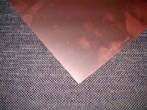 Folien aus Kupfer, "Basismaterial für Leiterplatten"
Es handelt sich um rechteckige massive Flacherzeugnisse (0,7 mm starke Platte) mit 
rechteckigem Querschnitt mit gleichbleibender Dicke, die auf beiden Seiten mit einer 
ca. 21 ym starken Kupferfolie aus raffiniertem Kupfer überzogen sind, mit einer Platte 
aus glasfasergewebeverstärkten Epoxidharz als Unterlage (4 Lagen Glasfasergewebe).
Die Erzeugnisse dienen als Grundmaterial für die Herstellung von elektronischen 
Verbindungsträgern (Leiterplatten, gedruckte Schaltungen).
Es handelt sich zolltariflich um Folien aus raffiniertem Kupfer mit einer Dicke von 0,15 mm oder 
weniger, auf einer Unterlage.