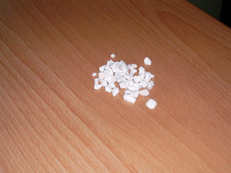Kaustisch gebranntes Magnesia, gewonnen aus natürlichem Magnesiumcarbonat, in Form von porösen, unregelmäßigen, weißlichen, zum Teil von bräunlichen und grauen Flecken durchzogenen, verschieden großen Körnern.