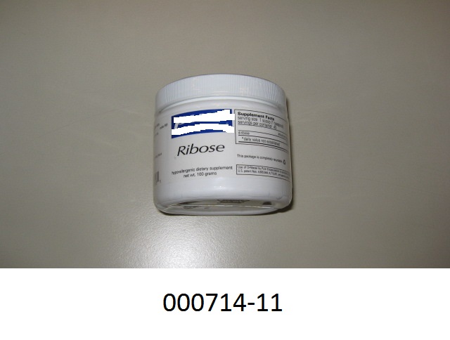 Weißer, pulverförmiger, chemisch reiner Zucker in Form des Monosaccharides Ribose (aus der Gruppe der Pentosen) mit Zusatz eines Trocknungsmittels; aufgemacht in einer etikettierten, weißen Kunststoffdose mit weißem, cellophanumhülltem Schraubverschluss, Innenversiegelung und Dosierlöffel.