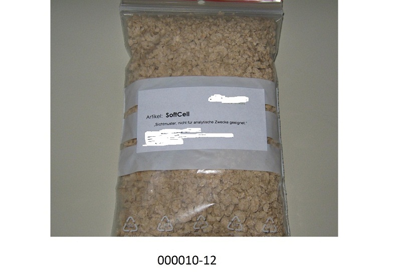 Hellbraune, aus Sägespänen bestehende, mit einem Pflanzenauszug behandelte Pellets, vermischt mit einem hellbraunen Pulver.