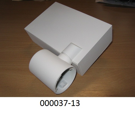 Teil eines Beleuchtungskörpers, bestehend aus einem mehrteiligen quaderförmigen Gehäuse aus unedlem Metall (Abmessungen (LxBxH): ca. 15,5 x 10 x 4,5 cm) mit runder Befestigungsvorrichtung (Adaptoraufnahme) und einem um +/-90° drehbaren zylinderförmigen Teil (Abmessungen (DxH): ca. 5 x 6,3 cm) in dem die Fassung zur Aufnahme eines G12 Leuchtmittels untergebracht ist. Der Leuchtenbauteil ist mit elektrischen Anschlussleitungen für das ins Gehäuse einzusetzende Vorschaltgerät (nicht Gegenstand dieser VZTA) ausgestattet.
(Abbildung siehe Anlage)