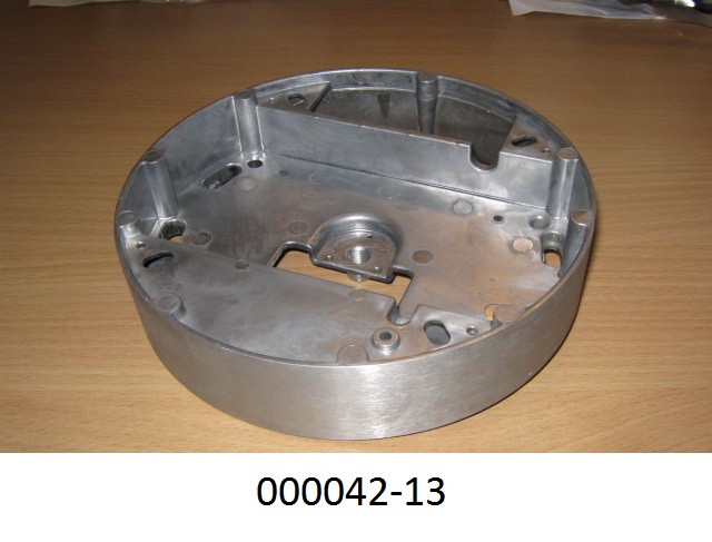 Teil eines Beleuchtungskörpers, bestehend aus einem maßhaltig nach Werkszeichnung gefertigten runden Aluminiumdruckgusskörper (Abmessungen DxH: ca. 16,5 x 3,5 cm) mit speziell geformten Aussparungen, Unterteilungen und Vertiefungen.
Der Leuchtenteil wird an den passend angebrachten Bohrungen an die Decke geschraubt und dient zur Aufnahme von Trafo, Anschlussklemmen und Seilabhängung.
(Abbildung siehe Anlage)