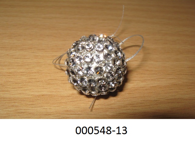 Ware aus Glaskurzwaren
- ballförmig, mit einem Durchmesser von ca. 19 mm,
- bestehend aus einer Glasperle, welche mit einer perlmutterfarbenen Schicht überzogen und in einem Metallnetz eingefasst ist,
- mit feuerpolierten Strasssteinen versehen, welche auf dem Metallnetz aufgeklebt sind, 
- die Glasperle und Strasssteine verleihen der Ware ihren Charakter.
 (Abbildung siehe Anlage)