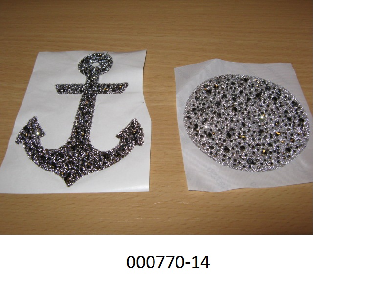 Zusammengesetzte Ware in Form eines „Bildes“ angeordnet aus Strasssteinen und Mikrokugeln (Edel- und Schmucksteine nachahmend),
- aufgebracht auf einer thermoplastischen Kunststoffschicht und auf der Vorder- und Rückseite mit einer Schutzfolie abgedeckt,
- die Strasssteine sind geschliffenen und mechanisch poliert, eine Hälfte ist mit einer goldfarbenen Schicht überzogen,
- die Mikrokugeln, mit einem Durchmesser von weniger als 1mm, sind zum Teil mit einer goldfarbenen Schicht überzogen,
- findet laut Antragsteller als Zierelement für Schmuck oder Textilien Anwendung.
- aufgrund der Zusammensetzung werden die Strasssteine als wesensbestimmend betrachtet.
(Abbildung siehe Anlage)