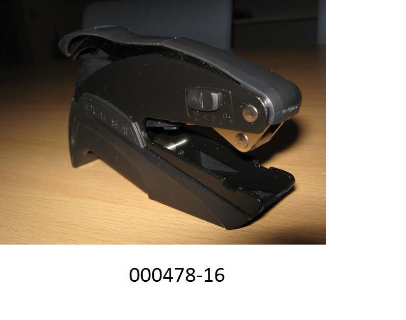 Zangenartig funktionierender Handprägeapparat aus unedlem Metall zum Prägen von kleinen Schildern, Etiketten, Briefpapier, Umschläge etc. bestehend aus:
- einem Stahlblech-Gehäuse mit Bedienhebel,
- einer durch Hebeldruck zu betätigenden Prägevorrichtung in Form von zwei runden Tellern (Durchmesser 41 mm) zur Aufnahme der Prägeplatten
(Abbildung siehe Anlage)