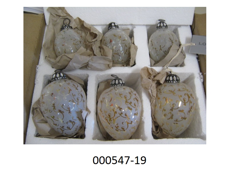 Weihnachtsartikel, in Form eines Sets Zieranhänger, 
- bestehend aus 6 Stück in unterschiedlichen Größen (Höhe 13 und 11cm; Durchmesser 9 und 8cm)
- bestehend aus einem ovalförmigen, nach unten spitz zulaufenden Hohlkörper aus milchigem Glas, welches mit floraren Elementen verarbeitet ist, 
- mit einer Aufhängevorrichtung aus unedlen Metallen (bestückt mit tropfenförmigen Glassteinen) mit Öse ausgestattet.
Aufgrund der Kombination von schimmernder Oberfläche, Form und der Aufhängevorrichtung handelt es sich bei dem Set dem Gesamteindruck nach um Dekorationsartikel für Weihnachtsbäume (Christbaumschmuck), die nach herkömmlichem Brauch zur traditionellen Ausgestaltung der Advents- und Weihnachtszeit verwendet werden.
Der Glasanteil überwiegt gegenüber dem unedlen Metall.
(Abbildung siehe Anlage, Materialangaben laut Antragsteller)