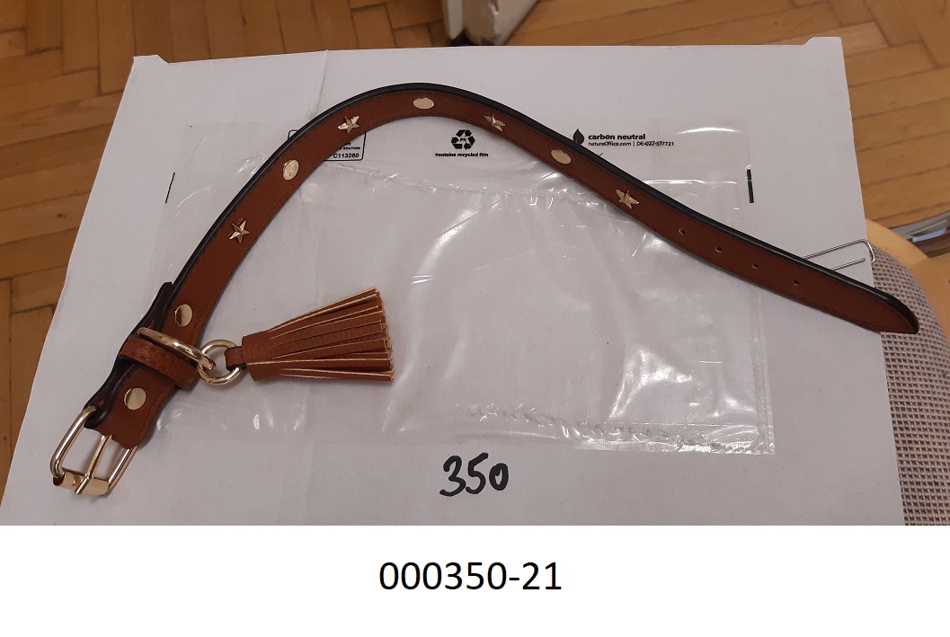 Sattlerware für Hunde, in Form eines Hundehalsbandes
- ca.42cm lang,
- mehrschichtig verarbeitet: Schaumkunststoff mit einer Lederimitataußenseite (Außenseite); Spinnstofflage; Schaumkunststofflage; Spinnstofflage; Schaumkunststoff mit einer Lederimitataußenseite (Außenseite);
- mit einer messingfarbenen Gürtelschnalle aus Metall verarbeitet,
- mit einer Schlaufe und einem messingfarbenen Metallring, an dem eine Quaste hängt, ausgestattet,
- mit Lochungen versehen.
(Abbildung siehe Anlage)