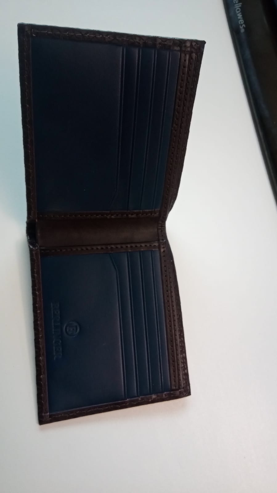 Behältnis in Form einer Geldbörse, 
- in nahezu rechteckiger Form gearbeitet (in geschlossenem Zustand),
- aufklappbar, innen mit zwei großen und 10 kleinen Fächern (für diverse Karten) verarbeitet,
- nicht verschließbar,
- mit einer Außenseite aus Leder,
- in den Fächern mit einem Gewebe aus Polyester ausgekleidet.
 (Abbildung siehe Anlage)