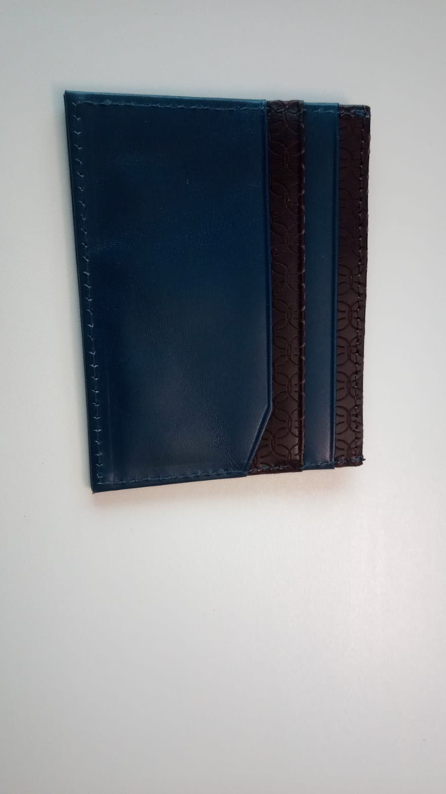 Behältnis (Handtaschenartikel) in Form eines Kartenetuis, 
- mit den Maßen von ca. 10 x 8cm,
- mit jeweils 3 Fächern an den beiden Außenseiten,
- an der Oberkante mit einem Fach ausgestattet, welches sich durch Druck an den Seiten öffnet,
- mit einer Außenseite aus Leder,
- in den Fächern mit einem Gewebe aus Polyester ausgekleidet.
 (Abbildung siehe Anlage)