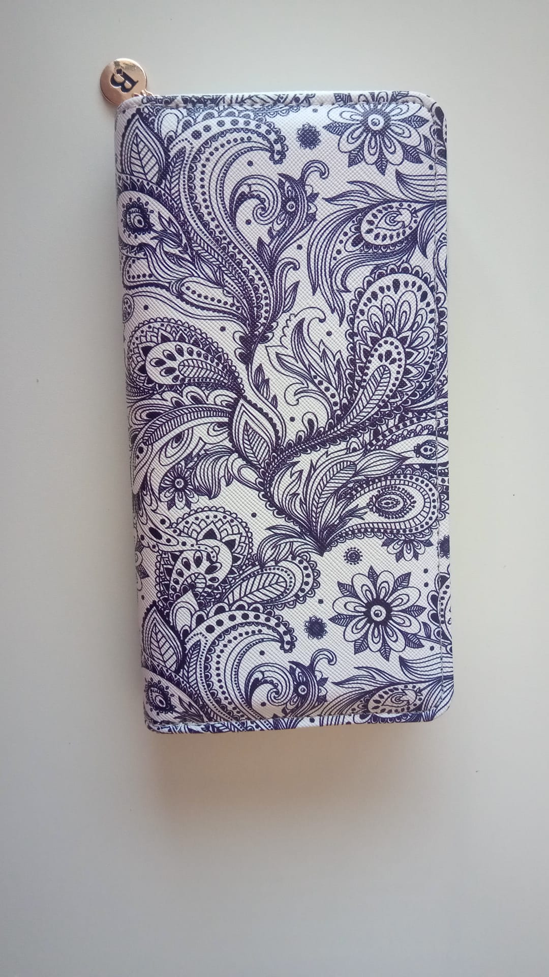Behältnis in Form einer Geldbörse, 
- mit den Abmessungen von ca. 20 x 10cm,
- bestehend aus einer Außenseite aus einer Kunststofffolie auf Polyurethanbasis, 
- innen mit diversen Fächern und Steckfächern verarbeitet,
- verschließbar mittels Zippverschluss,
- in einem Faltkarton verpackt.
(Abbildung siehe Anlage)