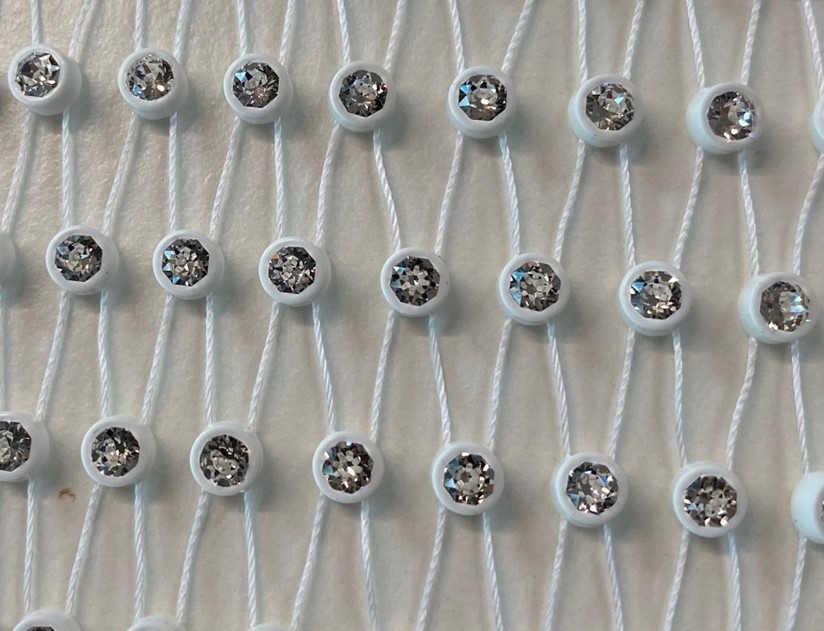Ware aus Glaskurzwaren
- in Form eines „Netzes“ (zur Untersuchung wurde ein Maß von ca. 43 x 34 cm vorgelegt),
- bestehend aus geschliffenen Strasssteinen in Kunststofffassungen, welche mit Schnüren aus Kunststoff miteinander verbunden sind,
- das Wesen der Ware wird von den Strasssteinen gebildet,
- findet in der Textil- und Accessoires-Industrie Verwendung.
(Abbildung siehe Anlage)