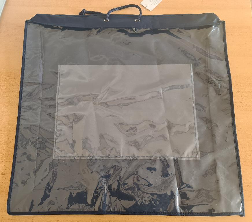 Beutel zu Verpackungszwecken, in Form eines Behältnisses zum Aufbewahren/Transportieren von Steppdecken, Kissen oder Oberbetten
- rechteckig zugeschnitten und in verschiedenen Größen vorliegend, 
- bestehend aus einem thermisch verfestigten Vlies aus Polypropylen (PP) an der Rückseite und an den Schmalseiten bzw. aus einer klarsichtigen Kunststofffolie (PEVA) an der Vorderseite (Schauseite),
- an einer Schmalseite ist ein kleines Einschubfach aus PEVA eingearbeitet,
- an den Kanten mit Randeinfassungen aus Vliesstoff verarbeitet,
- durch Zusammennähen konfektioniert,
- mit einer über drei Seiten verlaufenden Öffnung mit Reißverschluss auf der oberen Seite versehen,
- mit Tragegriffen aus Kordeln ausgestattet,
- im Hinblick auf den Umfang bestimmt der Vliesstoff aus synthetischen Spinnstoff gegenüber dem Kunststoff den Charakter der Ware.
(Abbildung siehe Anlage, Material laut Firmenangaben)