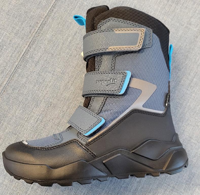 Schuh :
- den Knöchel, jedoch nicht die Wade bedeckend, 
- mit einem geschlossenen Blatt und drei Klettverschlüssen verarbeitet;
- mit einer profilierten Laufsohle aus Kunststoff versehen;
- bestehend aus einem Oberteil aus einem auf das Futter aufgebrachten Gewebe aus Polyester und Kunststoffteilen auf Polyurethanbasis bzw. aus aufgenähten Verstärkungsteilen aus Kunststoff; wenn man jene Teile, welche Verstärkungs- und Zubehörteile darstellen, außer Acht lässt, überwiegt der Spinnstoffanteil an der äußeren, sichtbaren Schicht des Obermaterials;
- nicht als Mädchen- oder Knabenschuh erkennbar;
- Länge der Innensohle mehr als 24cm;
- verpackt in einem Faltkarton.
Schuhe, welche ausschließlich oder im Wesentlichen beim Gehen getragen werden.
Gem. der Erläuterungen zur KN zu Position 6404, 3. Absatz, bilden Schuhe, welche ausschließlich oder im Wesentlichen beim Gehen, Trekking, Wandern oder Bergsteigen getragen werden, die Ausnahme zu "Schuhen für Sportzwecke".
Aufgrund der Verarbeitung, welche die Stabilität bzw. Festigkeit des Fußes im Schuh nicht gewährleistet, ist der gegenständliche Schuh nicht für Trainingszwecke (Sportzwecke) geeignet.
(Abbildung siehe Anlage)