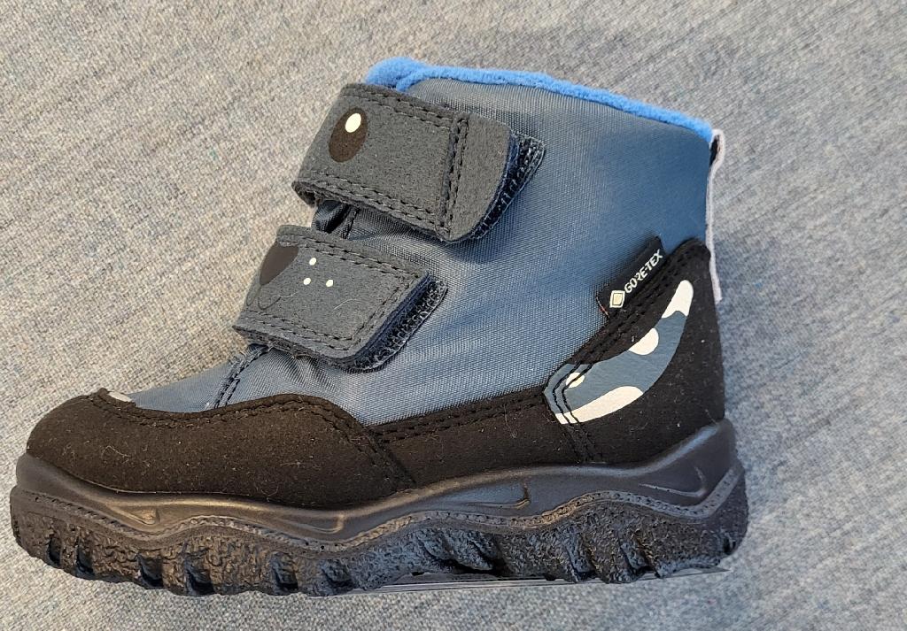 Schuh :
- den Knöchel bedeckend (jedoch nicht die Wade), 
- mit einem geschlossenen Blatt und Klettverschluss verarbeitet, 
- mit einer profilierten Laufsohle aus Kunststoff ausgestattet;
- bestehend aus einem auf das Futter aufgebrachten Gewebe und chemisch-verfestigten Vlies, jeweils aus Polyester; der textile Anteil überwiegt,
- nicht als Mädchen- oder Bubenschuh erkennbar;
- Länge der Innensohle kürzer als 24cm;
- verpackt in einem Faltkarton.
Schuhe, welche ausschließlich oder im Wesentlichen beim Gehen getragen werden.
Gem. der Erläuterungen zur KN zu Position 6404, 3. Absatz, bilden Schuhe, welche ausschließlich oder im Wesentlichen beim Gehen, Trekking, Wandern oder Bergsteigen getragen werden, die Ausnahme zu "Schuhen für Sportzwecke".
Aufgrund der Verarbeitung (keine Schnürung), welche die Stabilität bzw. Festigkeit des Fußes im Schuh nicht gewährleistet, ist der gegenständliche Schuh nicht für Trainingszwecke (Sportzwecke) geeignet.
(Abbildung siehe Anlage)