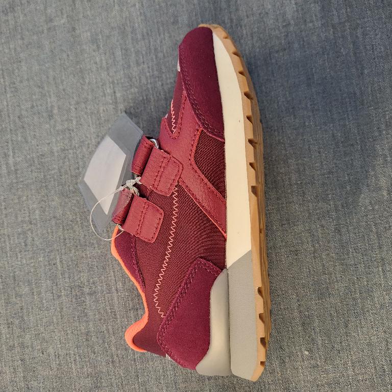 Schuh :
- den Knöchel nicht bedeckend, 
- mit einem geschlossenen Blatt verarbeitet, mittels zweier Klettverschlüsse verschließbar;
- mit einer profilierten Laufsohle aus Kautschuk versehen;
- bestehend aus einem Oberteil aus auf das Futter aufgebrachten Gewebeteilen aus Polyester und Lederteilen bzw. aus aufgenähten Verstärkungsteilen aus Kunststoff; wenn man jene Teile, welche Verstärkungs- und Zubehörteile darstellen, außer Acht lässt, überwiegt der Spinnstoffanteil an der äußeren, sichtbaren Schicht des Obermaterials;
- nicht als Mädchen- oder Knabenschuh erkennbar;
- Länge der Innensohle kürzer als 24cm;
- verpackt in einem Faltkarton.
Schuhe, welche ausschließlich oder im Wesentlichen beim Gehen getragen werden.
Gem. der Erläuterungen zur KN zu Position 6404, 3. Absatz, bilden Schuhe, welche ausschließlich oder im Wesentlichen beim Gehen, Trekking, Wandern oder Bergsteigen getragen werden, die Ausnahme zu "Schuhen für Sportzwecke".
Aufgrund der Verarbeitung, welche die Stabilität bzw. Festigkeit des Fußes im Schuh nicht gewährleistet, ist der gegenständliche Schuh nicht für Trainingszwecke (Sportzwecke) geeignet.
(Abbildung siehe Anlage)