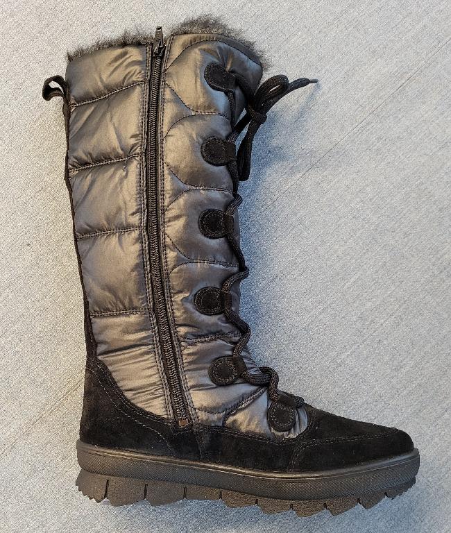 Schuh :
- den Knöchel, jedoch nicht die Wade ganz bedeckend, 
- mit einem geschlossenen Blatt verarbeitet, mittels Zippverschluss seitlich verschließbar bzw. mittels Schnürung an der Vorderseite verengbar;
- mit einer profilierten Laufsohle aus Kunststoff versehen;
- bestehend aus einem Oberteil aus auf das Futter aufgebrachten Kunststoffteilen auf Polyurethanbasis und Lederteilen, der Anteil an Kunststoff überwiegt;
- nicht als Mädchen- oder Knabenschuh erkennbar;
- Länge der Innensohle mehr als 24cm;
- aufgrund der Verarbeitung kein Sportschuh;
- verpackt in einem Faltkarton.
(Abbildung siehe Anlage)
