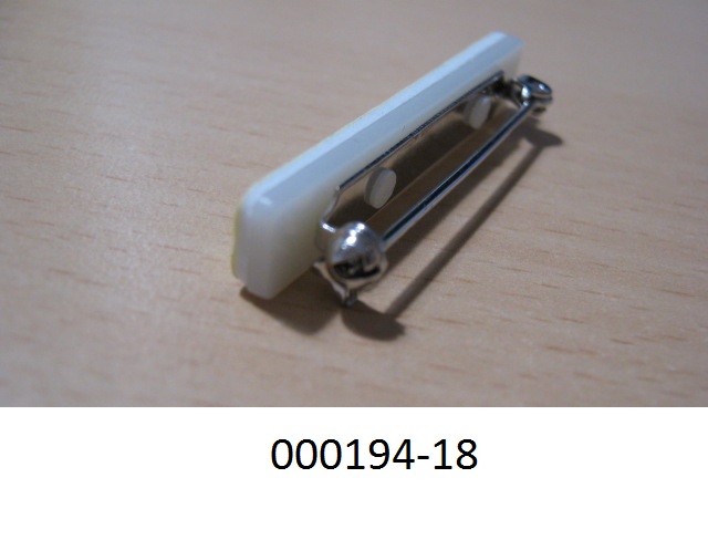 Zusammengesetzte Ware in Form einer Anstecknadel, bestehend aus 
- einer Sicherheitsnadel aus einem unedlen Metall,
- einem rechteckigen Kunststofftr?ger  (Materialangaben laut Antragsteller), mit den Ma?en von 40 x 6 x 2mm (LxBxH), welcher mit einer selbstklebenden Beschichtung aus EVA-Schaum versehen ist.
Die Sicherheitsnadel bestimmt im Hinblick auf die Verwendung den Charakter der Ware.
(Abbildung siehe Anlage)