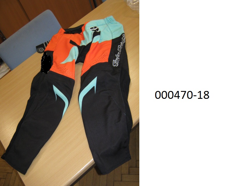 lange Hose (Motorradhose)
- beide Beine einzeln umschließend und bis zu den Knöcheln reichend,
- mit einem Zippverschluss verschließbar und links über rechts mittels Gürtel verengbar (für Männer oder Knaben), 
- bestehend aus verschieden bedruckten/gefärbten Geweben (Multifilamentgarne aus Polyester) bzw. in der Kniekehle und im hinteren Unterschenkelbereich aus einem eingenähten Lederteil,
- aufgrund der Verarbeitung als Motorradhose für Männer oder Knaben erkennbar, keine Arbeits- oder Berufsbekleidung,
- das Gewebe überwiegt überwiegt an der Ware und ist somit wesensbestimmend,
- verpackt in einem Kunststoffbeutel.
(Abbildung siehe Anlage)