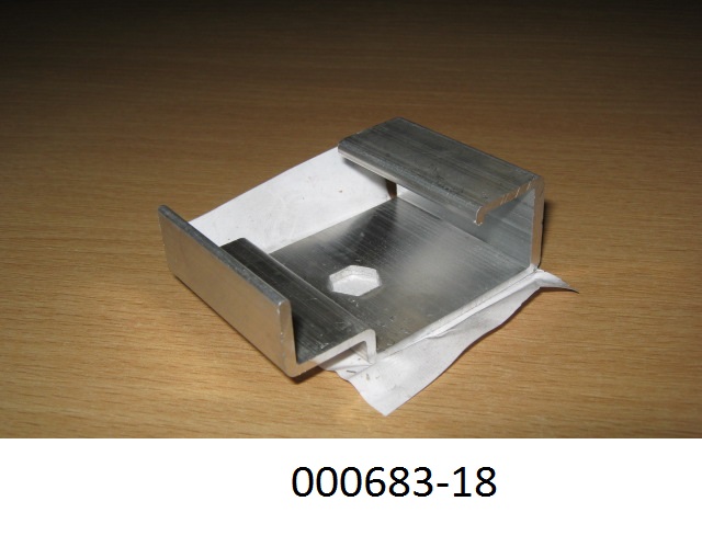G-förmiger Bauteil aus nicht legiertem, stranggepresstem Aluminium (Abmessungen: ca. 4 x 6 x 2,1 cm), welcher mittig eine sechseckige Öffnung besitzt und zu Konstruktionszwecken dient.
Mit einem Gehalt von 99,94 GHT an Aluminium (Al), sowie Anteil an Eisen (Fe), Zink (Zn), Nickel (Ni).
(Abbildung siehe Anlage)