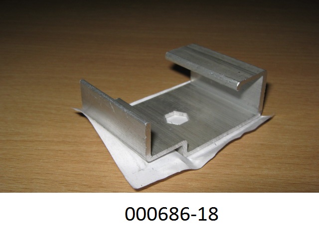 G-förmiger Bauteil aus nicht legiertem, stranggepresstem Aluminium (Abmessungen: ca. 4 x 6 x 2,1 cm), welcher mittig eine sechseckige Öffnung, auf der Unterseite ein Gewinde und eine weitere Runde Öffnung besitzt und zu Konstruktionszwecken dient.
Mit einem Gehalt von 99,89 GHT an Aluminium (Al), sowie Anteil an Eisen (Fe), Zink (Zn), Nickel (Ni).
(Abbildung siehe Anlage)