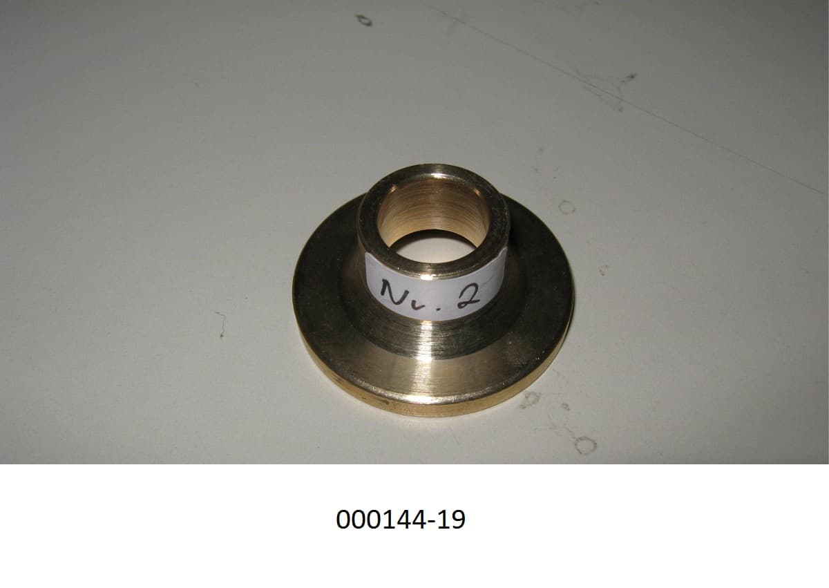 Messingfarbene Kappe mit einer Höhe von 15,9 mm, in der Vorderansicht t-förmige Kappe, mit einem größten Durchmesser von 35,8 mm und einer Öffnung an der Schmalseite von 12,9 mm.
Mit einem Gehalt von mehr als 59 GHT an Kupfer (Cu), sowie Anteilen an Zink (Zn), Blei (Pb), Zinn (Sn), Eisen (Fe), Nickel (Ni) und anderen Elementen.
Die Kappe besteht aus Messing.
(Abbildung siehe Anlage)