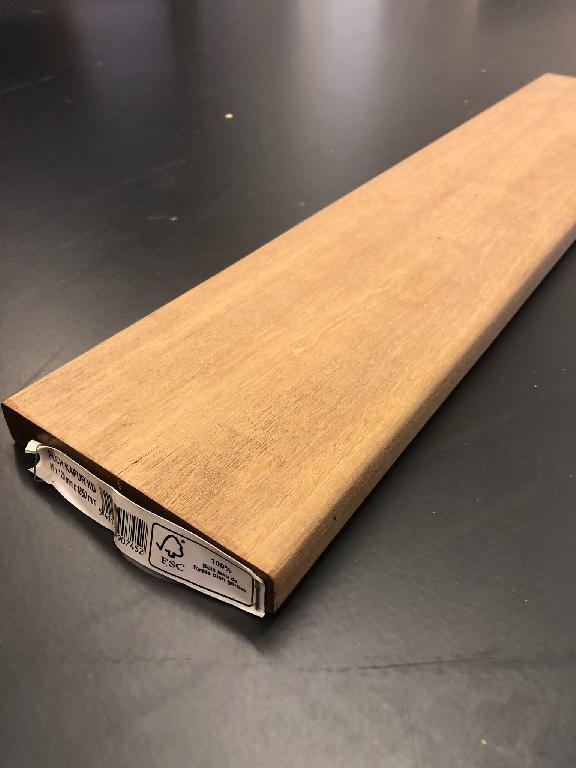 Een volgens opgave geschaafde terrasplank van Kapur, met een nagenoeg rechthoekige doorsnede, voorzien van licht afgeronde hoeken over de hele lengte van de plank, die de samenvoeging geenszins bevorderen.
De dikte is meer dan 6 mm.