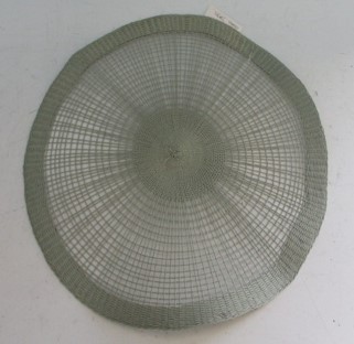 Een grijskleurige zogenaamde pace-mat vervaardigd van papiergaren, in ronde vorm, grotendeels bestaande uit een open weefsel, centraal en aan de buitenkant betreft het een gesloten weefsel.

Het artikel heeft een diameter van 38 cm.