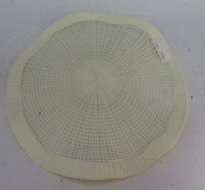 Een witte, zogenaamde place-mat vervaardigd van papiergaren, in ronde vorm, grotendeels bestaande uit een open weefsel, centraal en aan de buitenkant betreft het een gesloten weefsel.

Het artikel heeft een diameter van 38 cm.