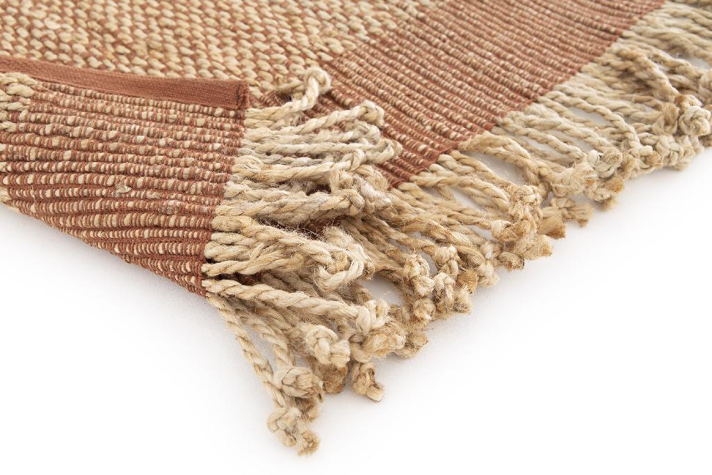 Een handgeweven vlak mini tapijt zonder pool en ruggensteun, met franjes langsheen de lange zijden. Het tapijt is gemaakt met de pitloom techniek en vervaardigt uit jute en katoen.

Het tapijt omvat een platbinding weefsel van dun bruin katoenen garen met een extra inslag van dik jute. De korte zijden hebben een boord van dun bruin katoenen garen.

Het product is 30 cm breed (zonder franjes) en ongeveer 60 cm lang .