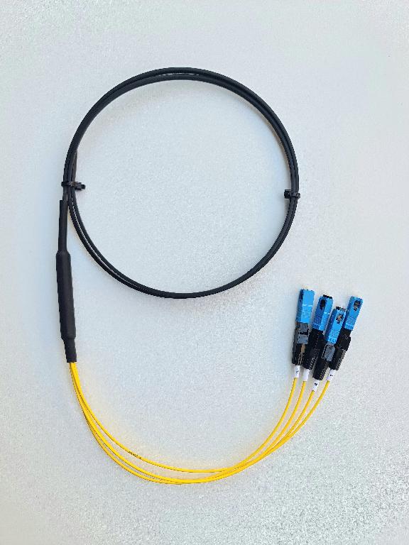 Оптичен кабел (тип FTTH – Fiber To The Home), съставен от 4 индивидуално оцветени едномодови влакна тип G.657A, с два подсилващи FRP елемента с диаметър 2 х 0.45mm и носещо метално въже с диаметър 1.20mm. Кабелът е с общ диаметър 6.15mm H x 2.9 mm W и е защитен и изолиран с LSZH  обвивка. 
Всяко влакно в единия си край е снабдено с конектор SC/UPC. Кабелът се предлага на дървени макари с дължина от 500 m до 2000 m.