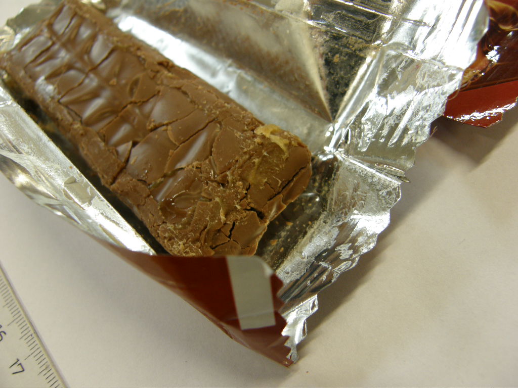 Dle údajů žadatele se jedná o tyčinku z karamelu a nugátu v mléčné čokoládě.
Popis výrobku: tyčinka o rozměrech cca 10,5 x 3,5 x 1,3 cm tvořená karamelem a nugátem v mléčné čokoládě.
Deklarované balení: balení pro drobný prodej - hmotnost 40 g; tyčinka je zabalena do alu-fólie s barevným potiskem; 24 kusů tyčinek v kartonu po 6 krabičkách.