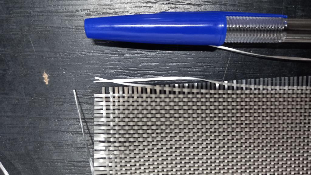 Dle deklarovaných informací a přiložené fotodokumentace se jedná o mechanicky pojenou tkaninu ze skleněné příze (e-glass) impregnované silanem, s uzavřeným očkem, v plátnové vazbě. Tkanina je navinuta na válcové role (o šířce od 100 cm do 127 cm).