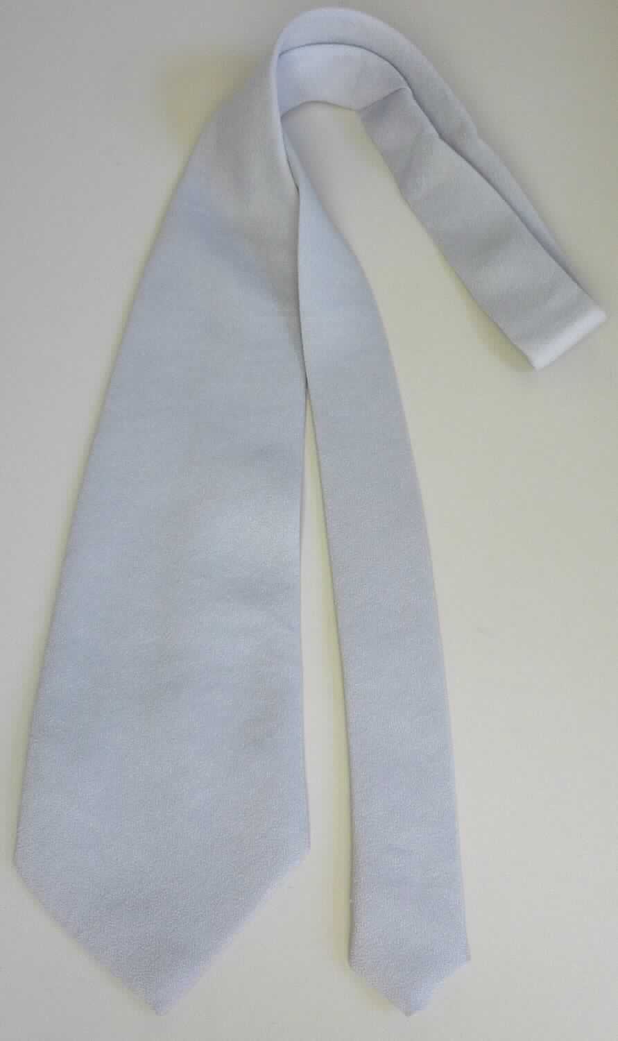 Krawatte, Art. KRAN-1-(S), Foto siehe Anlage,
- in einem Polybeutel verpackt,
- bis zu 9,5 cm breit und ca. 137 cm lang; an den Enden spitz zulaufend,
- aus ca. 0,5 mm dicken, einfarbigen Geweben aus laut Antrag 100 % Polyester (synthetische Chemiefasern),
- zweilagig gearbeitet und mit einem Innenfutter ausgestattet,
- durch Zusammennähen konfektioniert,
- ohne Hinweise auf Handarbeit.

"Krawatte, aus Geweben, aus Chemiefasern, nicht handgearbeitet"