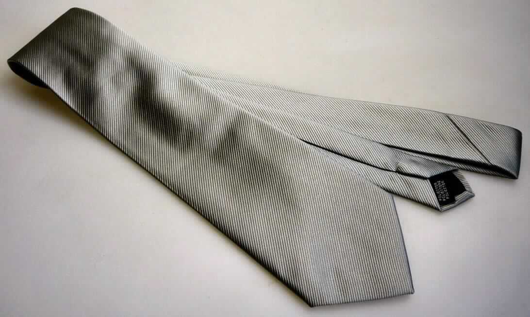 Krawatte, sog. Krawatte mit Schrägdekor, Art. KRA-2-S, Foto siehe Anlage,
- aus einfarbigen Geweben aus laut Antrag 100 % Polyester (synthetische Chemiefasern),
- bis zu 9 cm breit und ca. 140 cm lang; an den Enden spitz zulaufend,
- zweilagig gearbeitet und mit einem Innenfutter ausgestattet,
- durch Nähen konfektioniert,
- ohne Hinweise auf Handarbeit.

"Krawatte, aus Geweben, aus Chemiefasern, nicht handgearbeitet"