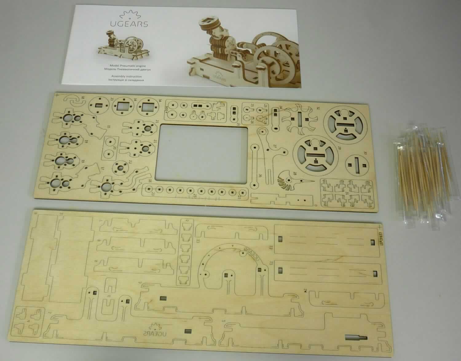 Bei dem vorgelegten Warenmuster (sog. "3D-Holzfunktionsbausatz") handelt es sich um ein maßstabgetreues 
Modell eines pneumatischen Motors aus Holz (Maßstab 1: 87) zum Zusammenbauen. Das Modell besteht aus 81 Bauteilen, einer Tüte mit mehreren Verbindungselementen in Form von kleinen, dünnen Holzstäben und einer mit Abbildungen und Text versehenen Bauanleitung. Die Bauteile befinden sich auf zwei Holzplatten und sind bereits maschinell vorgeschnitten. Laut Angaben können sie vorsichtig mit den Fingern oder unter Zuhilfenahme eines Messers herausgelöst und entsprechend der beigefügten Bauanleitung zusammengesteckt werden. Zum Zusammenstecken werden auch die Verbindungsstäbe benötigt, die noch entsprechend der Anleitung zugeschnitten werden müssen. Die Ware dient der Unterhaltung von Personen und ist in einem Karton mit Sichtfenster für den Einzelverkauf aufgemacht.

Zolltarifrechtlich liegt ein "maßstabsgetreu verkleinertes Modell zum Zusammenbauen" vor.
