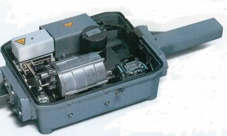 Weichenantrieb, Foto siehe Anlage,
- in einem Schutzgegäuse (Schutzart IP54) mit Gehäusedeckel mit Einbauschloss, 
- mit einer Steuerelektronik, 
- mit einem Motor, einem Zahnradgetriebe und einem Kugelgewindetrieb,
- dient in Gleisbildstellwerken, elektromechanischen und elektronischen Stellwerken über 
  unterschiedliche Stellentfernungen (Distanz zwischen dem Schaltraum des Stellwerks 
  und dem anzusteuernden Weichenantrieb) im Wesentlichen dem Umstellen von Weichen;
  dazu wird die Drehbewegung des Motors über das Zahnradgetriebe auf den Kugelgewinde-
  trieb übertragen und in eine Längsbewegung zur Einstellung der Weichenzungen
  umgewandelt,
- daneben werden 
- - die Weichenzungen in den Endlagen festgehalten,
- - der Weichenverschluss mechanisch gesichert,
- - der Stellvorgang elektrisch an das Stellwerk gemeldet.

"Elektromechanisches Steuergerät für Schienenwege (Weichenantrieb)"