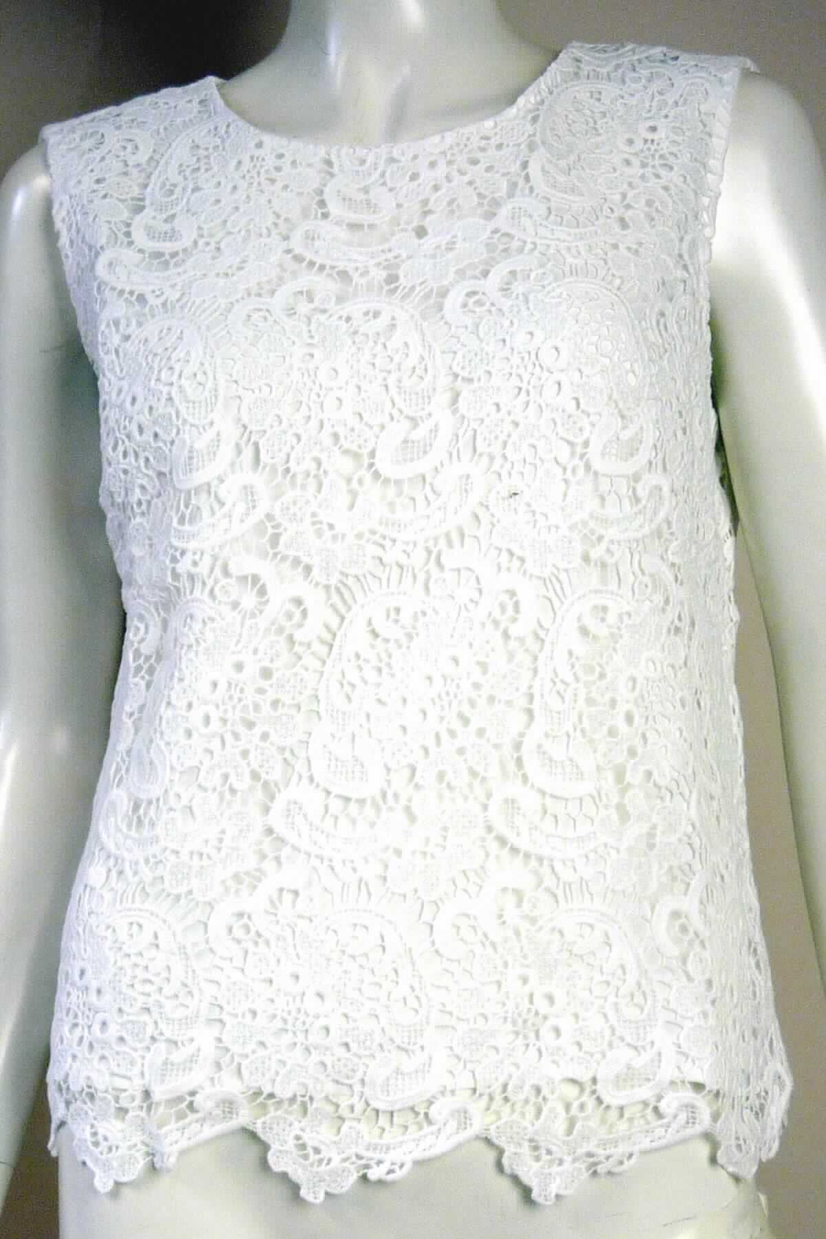 Kleidung, sog. Spitzenshirt, Größe 38, Foto siehe Anlage,
- doppellagig gearbeitet, mit einer Außenlage aus bis zu ca. 1,7 mm dicken, einfarbigen Ätzstickereien aus laut 
  Antrag 100 % Baumwolle und einer Innenlage aus ca. 0,2 mm dicken, einfarbigen Geweben aus laut Antrag 
  100 % Polyester (synthetische Chemiefasern); beide Lagen sind am Hals- und an den Armausschnitten 
  dauerhaft zusammengenäht; aufgrund der Dicke nicht mehr leicht, somit keine Bluse,
- über die Taille reichend (Rückenlänge: ca. 54 cm), 
- mit einem runden Halsausschnitt, 
- hinten mit einer kurzen Öffnung mit Knopfverschluss,
- ohne Hinweise auf den Trägerkreis (unisex), 
- ärmellos, 
- am unteren Rand mit einem bogigen, dem Muster der Stickerei entsprechenden Abschluss (Außenlage) bzw. 
  durch Umschlagen und Festnähen gesäumt (Innenlage),
- keine Arbeits- und Berufskleidung,
- insbesondere im Hinblick auf das äußere Erscheinungsbild herrscht das Gewebe aus Baumwolle vor und bildet
  damit das für die Spinnstoffermittlung maßgebende Flächenerzeugnis.

"Kleidung, andere als in den Positionen 6201 bis 6210 und in den Unterpositionen 6211 11 bis 6211 20 genannte,
 aus Stickereien, für Frauen, aus Baumwolle, andere als in den Unterpositionen 6211 4210 bis 6211 4242 
 genannte"