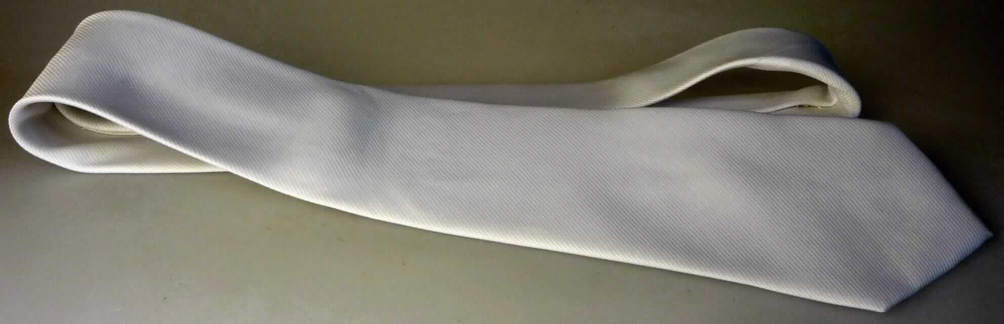 Krawatte, sog. Krawatte mit Schrägdekor, Art. KRA-2-W, Foto siehe Anlage,
- aus einfarbigen Geweben aus laut Antrag 100 % Polyester (synthetische Chemiefasern),
- bis zu 8,5 cm breit und ca. 152 cm lang; an den Enden spitz zulaufend,
- zweilagig gearbeitet und mit einem Innenfutter ausgestattet,
- durch Nähen konfektioniert,
- ohne Hinweise auf Handarbeit.

"Krawatte, aus Geweben, aus Chemiefasern, nicht handgearbeitet"