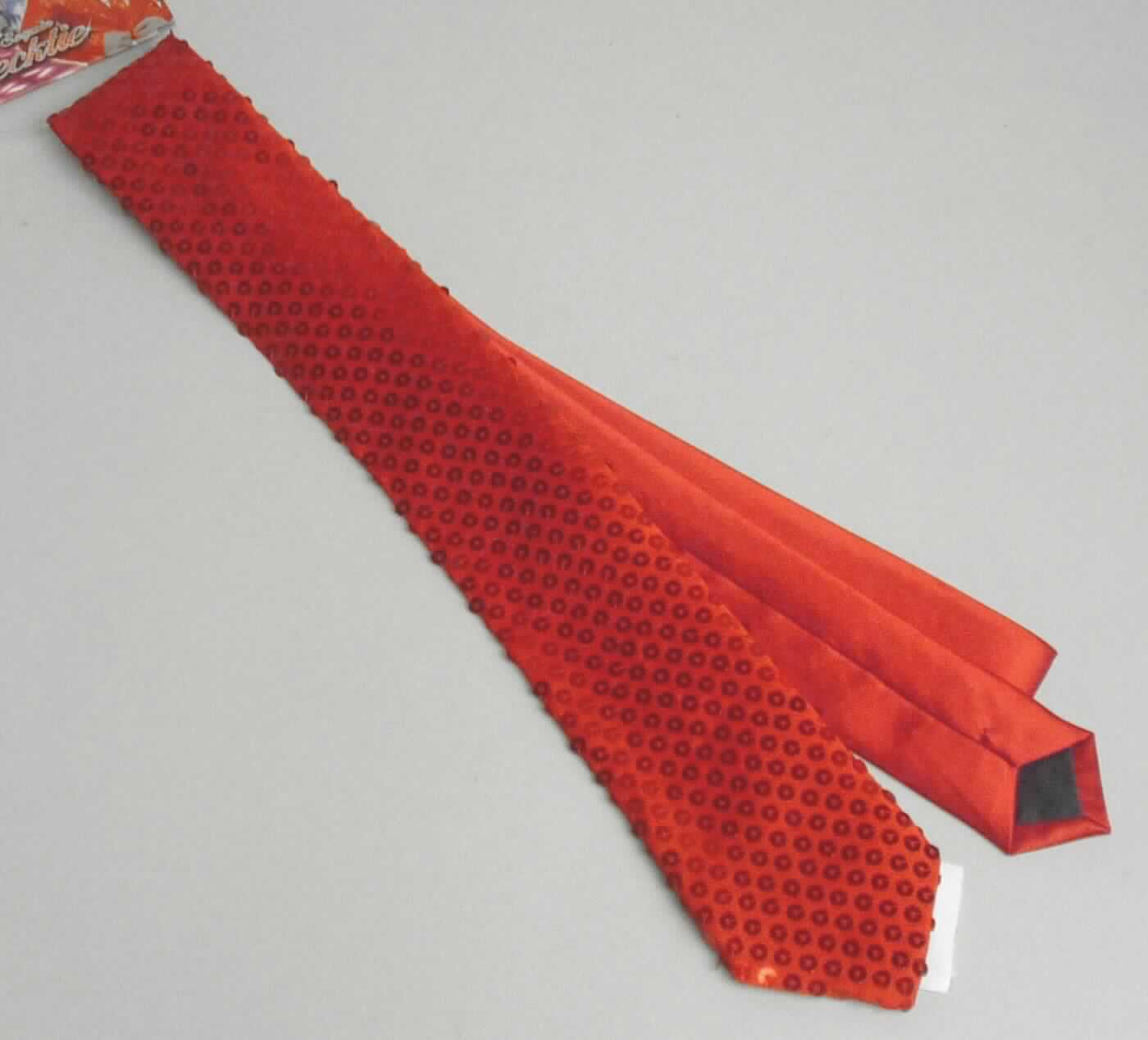 Paillettenkrawatte, Art. 92078, Foto siehe Anlage,
- in einem Polybeutel mit Pappaufhänger verpackt,
- bis zu 6,5 cm breit und ca. 144 cm lang; an den Enden spitz zulaufend,
- mit einem ca. 44 cm langen, breiten Ende aus einer Applikationsstickerei (Pailletten) der Position 5810 mit einem 
  Stickgrund aus Geweben und einem ca. 100 cm langen, schmalen Ende aus einfarbigen Geweben,
- alle Flächenerzeugnisse aus lt. Antrag 100 % Polyester (synthetische Chemiefasern),
- zweilagig gearbeitet und mit einem Innenfutter ausgestattet,
- durch Zusammennähen konfektioniert,
- ohne Hinweise auf Handarbeit.

"Krawatte, aus Stickereien und Geweben, aus Chemiefasern, nicht handgearbeitet"