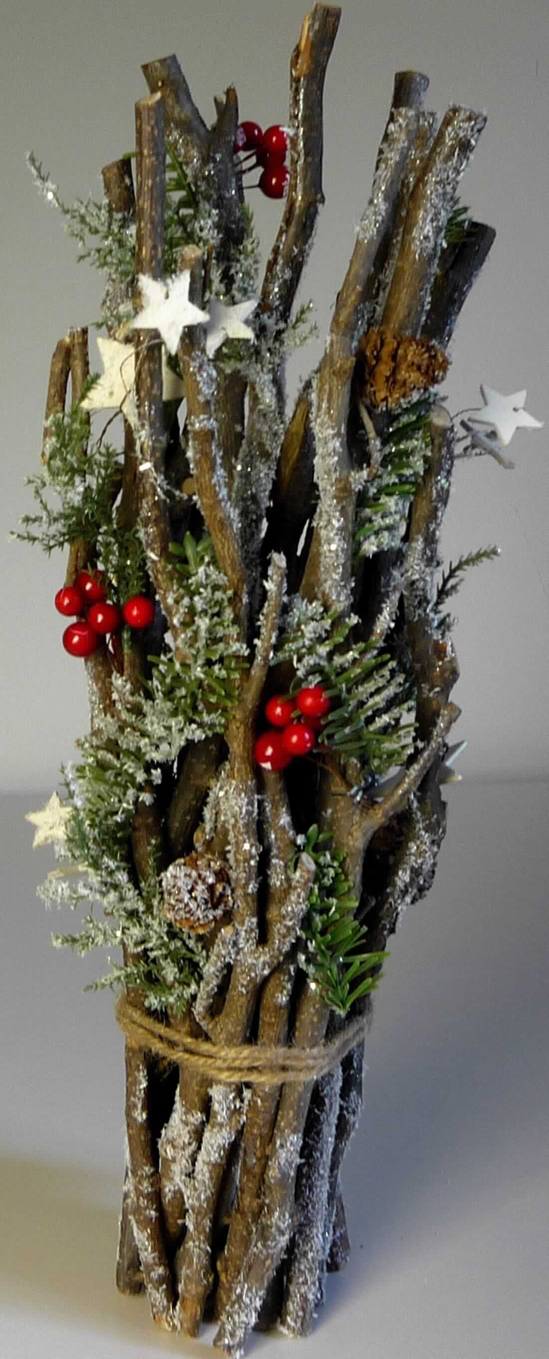 "Dekoartikel Zweig, Art. 229.631-632"
- aus ca. 35 - 46 cm langen, starren Zweigen (Kiefer- und Birkenholz, lt. Antragsteller), aneinander genagelt und mit 
  Juteband (lt. Antragsteller) umwickelt (Zutaten), 
-- mit an den Zweigen vernagelten unterschiedlich großen, sternförmigen Sperrholzzuschnitten, natürlichen Zapfen 
   (Pflanzenteile), künstlichen Beeren (künstliche Früchte) sowie Nachbildungen von Nadelbaumzweigen aus 
   Kunststoff (nicht aus mehreren Teilen bestehend, kein künstliches Blattwerk) versehen,
- mit künstlichem Schnee und Glitter verziert
- zu Binde- und Zierzwecken, wird üblicherweise im Blumenhandel verkauft.
(Abbildung siehe Anlage)

Der Charakter des Ganzen wird hinsichtlich des Umfangs, Menge und der Bedeutung für die Verwendung (Zierwirkung) durch die weitergehend bearbeiteten Pflanzenteile (Zweige und Zapfen) bestimmt.

"Andere Pflanzenteile als Moose und Flechten, ohne Blüten und Blütenknospen, zu Binde- und Zierzwecken 
(zusammengesetzte Ware aus getrockneten und weitergehend bearbeiteten Pflanzenteilen -charakterbestimmend-, Holz, Kunststoff und künstliche Früchte)"