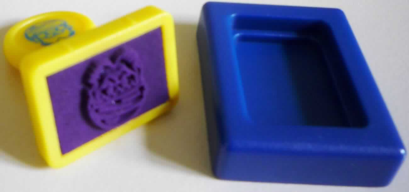 Es handelt sich um bei dem als Stempel Nikolaus bezeichneten Erzeugnis um eine aus zwei Bestandteilen zusammengesetzte Ware, bestehend aus einem ca.  20 x 15 mm großen Stempel und einer passgenauen, flachen Stempelhalterung aus Kunststoff (ca. 28 x 23 mm).

Der Stempel (charakterbestimmend im Hinblick auf die Verwendung) besteht aus einem Griff und einer getränkten Grundplatte mit der Abbildung eines Nikolauskopfes.

Die Ware ist als "Stempel für den Handgebrauch" einzureihen.