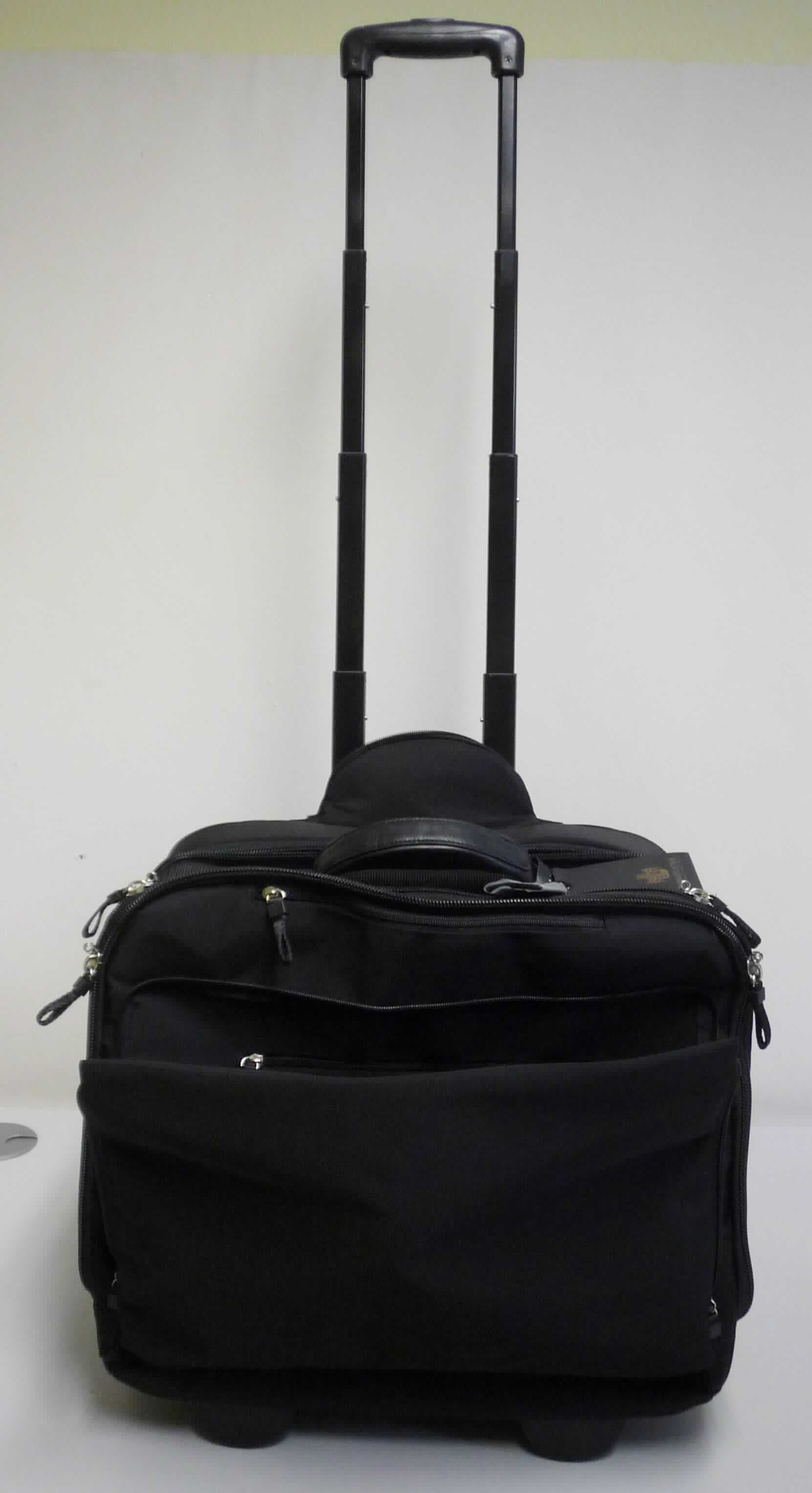 Handkofferähnliches Behältnis, sog. Business Trolley L. HEYDEN SOHO (Art. 9077368), Foto siehe Anlage,
- mit einer Außenseite aus Spinnstoffen,
- in den Abmessungen: ca. 46 cm (Breite) x 38 cm (Höhe) x 24 cm (Tiefe),
- mit einem Handtragegriff,
- in einem Reißverschlussfach an der Rückseite mit einem ausziehbaren Griff zum Ziehen des Koffers auf
  zwei Rollen (Trolleyfunktion); im Bereich der Rollen zur Verstärkung mit einer Leiste aus formgepresstem
  Kunststoff ausgestattet,
- mit zwei Stellfüßen aus Kunststoff,
- mit einem aufgesetzten Vorfach mit einem an drei Seiten verlaufenden Reißverschluss, das mit Dehnfalte,
  drei offenen Einsteckfächern, drei Stiftschlaufen, einem Karabinerhaken und einem eingesetzten
  Reißverschlussfach ausgestattet ist,
- mit einem oberhalb des Vorfachs eingesetzten Reißverschlussfach,
- mit drei Hauptfächern, jeweils mit einem an drei Seiten umlaufenden Doppelreißverschluss zu öffnen,
- - vorderes Hauptfach mit zwei Trennstegen,
- - mittleres Hauptfach mit elastischen Kreuzpackgurten,
- - hinteres Hauptfach mit einem offenen, gepolsterten Einsteckfach, z. B. zur Aufnahme eine Laptops,
    einem darauf aufgesetzten Reißverschlussfach aus Netzgewirken und auf der gegenüberliegenden
    Seite mit drei aufgesetzten, offenen Einsteckfächern aus Netzgewirken,
- auf der Rückseite mit einem quer verlaufenden Streifen aus Spinnstoffen mit je einem doppelten
  Reißverschluss an der Ober- und Unterseite zur Befestigung des handkofferähnlichen Behältnisses
  an einem weiteren Trolley,
- ohne Hinweise auf Handarbeit.

"Handkofferähnliches Behältnis, mit Außenseite aus Spinnstoffen, nicht handgearbeitet"