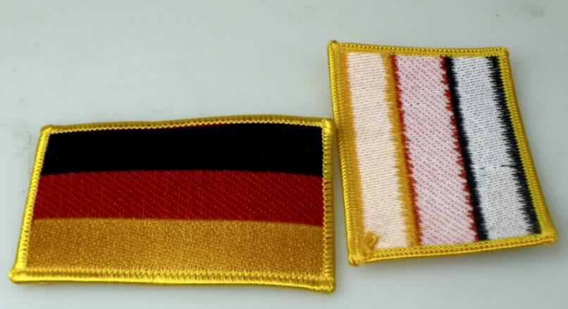 Stickerei, sog. Aufnäher, gesticktes Flaggenmotiv, Foto siehe Anlage,
- Motivstickerei "Deutschlandfahne",
- in den Abmessungen: etwa 8,5 cm x 5,5 cm,
- keine Ätzstickerei oder Stickerei mit herausgeschnittenem Grund,
- laut Antrag maschinell hergestellt,
- mit einem Stickgrund aus Gewebe aus laut Antrag 65 % Polyester (synthetische Chemiefasern) 
  und 35 % Baumwolle,
- auf der Rückseite mit Kunststoff beschichtet, 
- laut Antrag mit einem Wert von mehr als 17,50 EURO je kg Eigengewicht,
- nicht handgearbeitet,
- laut Antrag zum Aufbügeln auf z. B. Kleidungsstücke.

"Stickerei als Motiv, keine Ätzstickerei oder Stickerei mit herausgeschnittenem Grund, aus Chemiefasern,
 mit einem Wert von mehr als 17,50 EUR je kg Eigengewicht, nicht handgearbeitet"