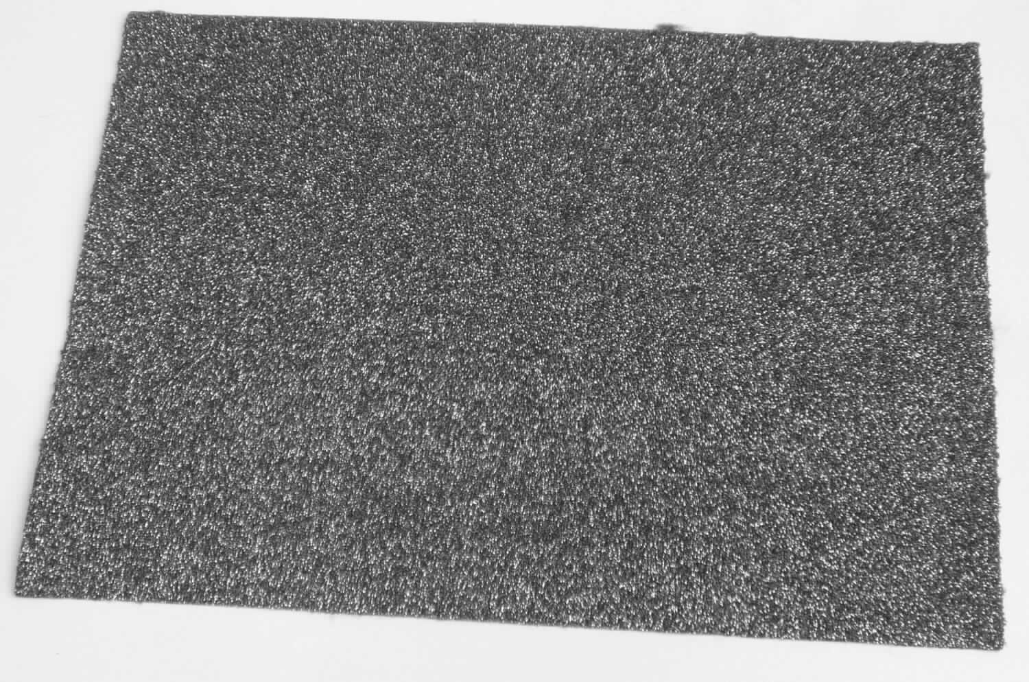 Überzogenes Gewebe, Foto siehe Anlage,
- als Meterware,
- laut Untersuchungsergebnis:
-- aus einem Gewirke (= Gewebe im Sinne des Kapitels 59) aus laut Antrag 100 % Polyester (synthetische 
   Chemiefasern),
-- auf der Schauseite auf der ganzen Oberfläche mit einem Kleber bestrichen und flächendeckend mit einer Lage
   aus metallisierten Kunststoff-Partikeln (keine Kügelchen) überdeckt,
- dient laut Antrag als Obermaterial für Schuhe.

"Überzogenes Gewebe, anderes als in den Positionen 5901 bis 5906 genannte, ohne eingebettete Kügelchen"