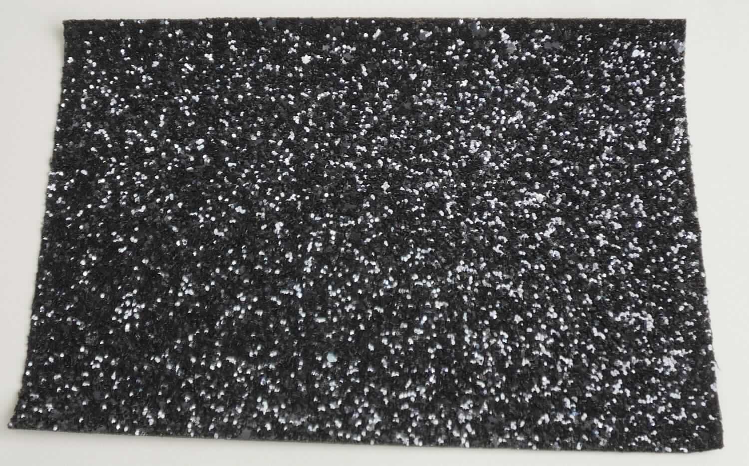 Überzogenes Gewebe, Foto siehe Anlage,
- als Meterware,
- laut Untersuchungsergebnis:
-- aus einem Gewebe aus laut Antrag Polyester (synthetische Chemiefasern) und Baumwolle,
-- auf der Schauseite auf der ganzen Oberfläche mit einem Kleber bestrichen und flächendeckend mit einer Lage
   aus metallisierten Kunststoff-Partikeln (keine Kügelchen) überdeckt,
- dient laut Antrag als Obermaterial für Schuhe.

"Überzogenes Gewebe, anderes als in den Positionen 5901 bis 5906 genannte, ohne eingebettete Kügelchen"